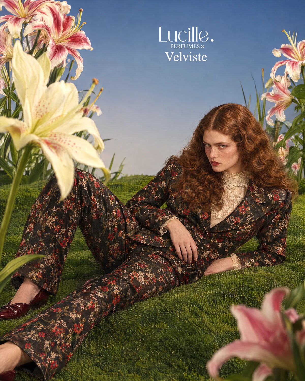Velviste: An auburn-haired woman in a floral suit reclining on grass among oversized flowers