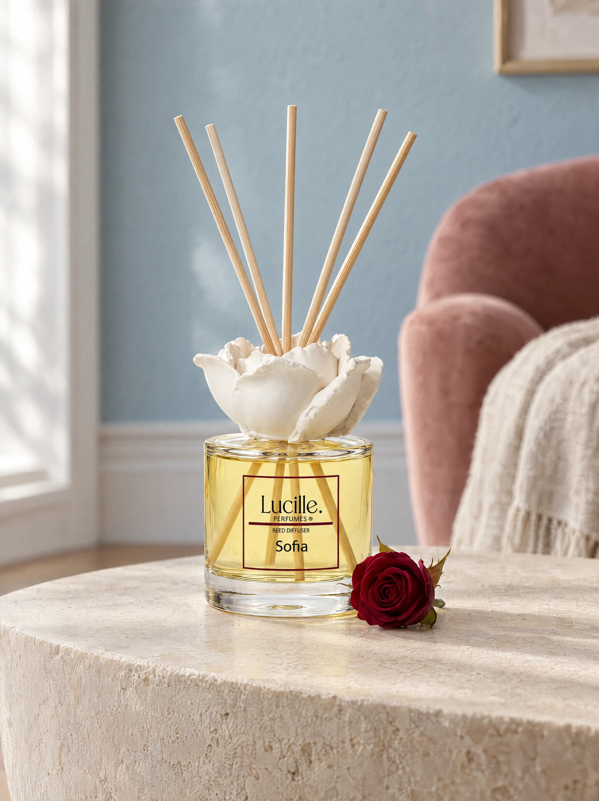 Sofia 130 ml beside a red rose before a pink armchair, styled with an optional gypsum flower accessory